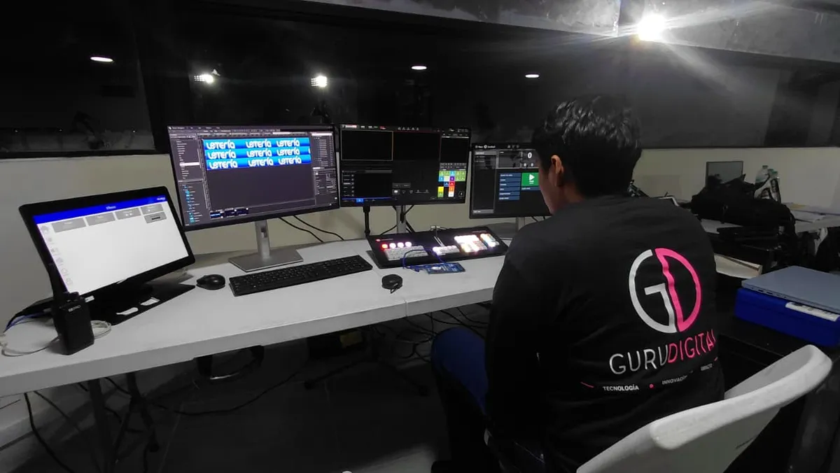 Operador de Guru Digital en la sala de control, frente a los monitores de contenido, el switcher de video y la consola del sistema